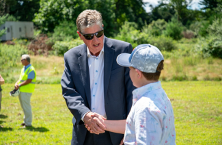 Gov McKee Shaking hands with a kid