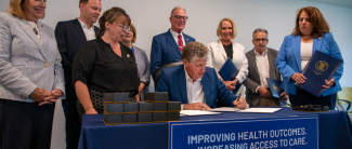 Gov McKee signing a document